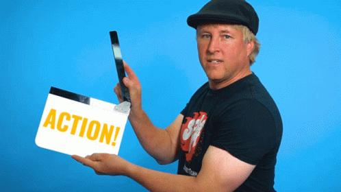 Man holding a clapperboard with "Action" written on it
