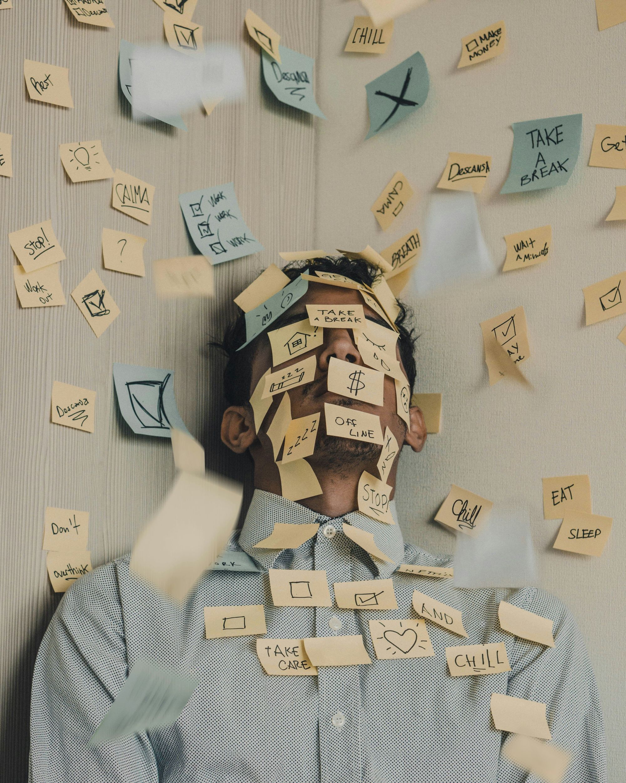 Person laying on floor with yellow sticky notes on face and arms